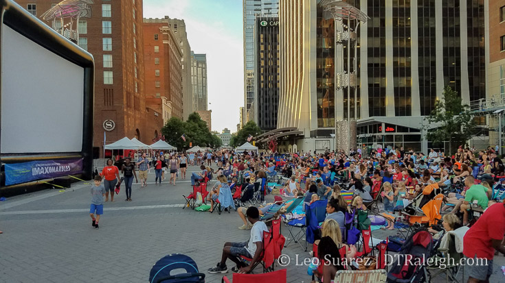 Raleighites sit all over City Plaza waiting to watch a movie on a large inflatable screen. July 2016.