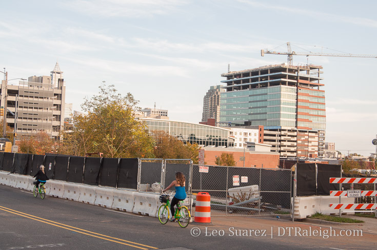 Limebike riders pass in front of the former warehouse of Shelton's Furniture on Morgan Street, November 2017.