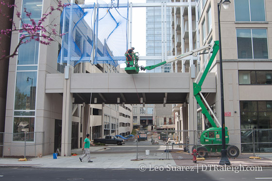 Artwork being installed over the vehicle entrance along Blount Street.