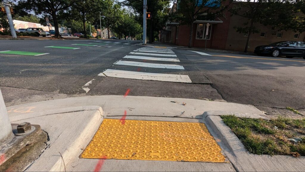 lowered curb with tactile pavers and crosswalk on city intersection